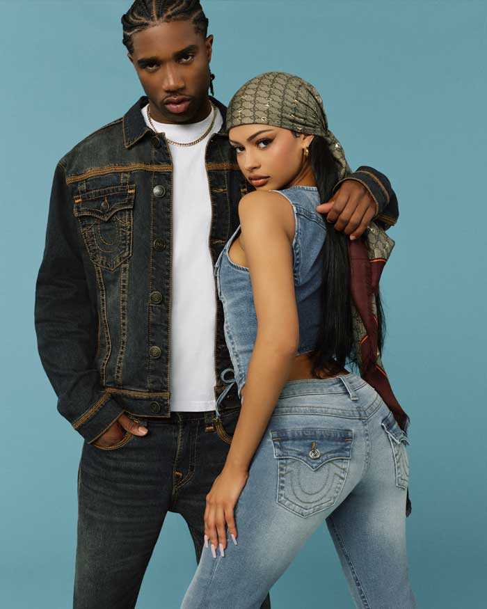 Man wears true religion acid wash jean jacket, white tee shirt, and true religion acid wash straight leg jeans. Woman wears true religion jean vest and true religion jeans